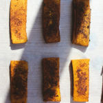 8 slices of golden tofu on a piece of parchment paper