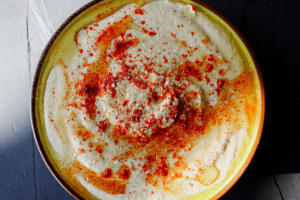 Bowl of hummus with olive oil and paprika on top